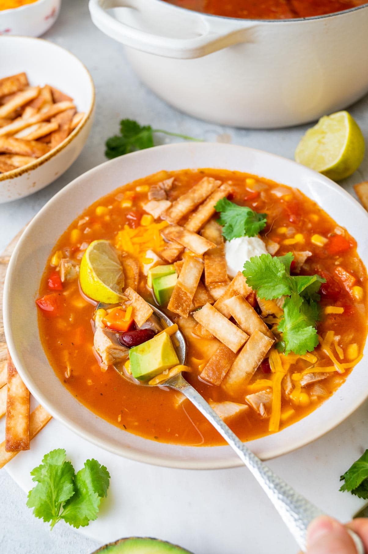 Turkey tortilla soup in a white bowl.