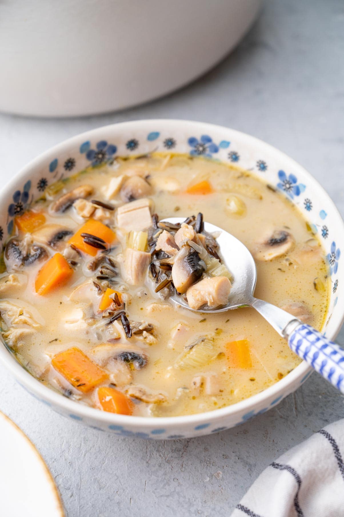 Turkey wild rice soup in a white-blue bowl.