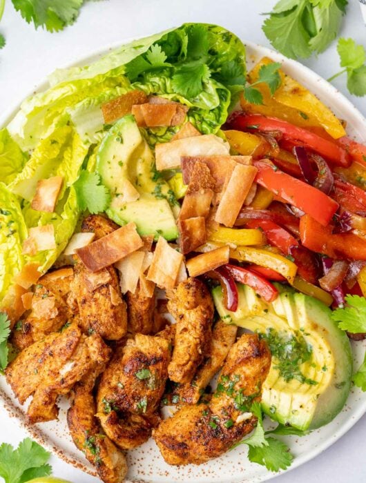 Chicken fajita salad on a white plate.