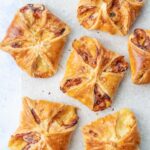 Ham and cheese puff pastry appetizers on a grey stone board.