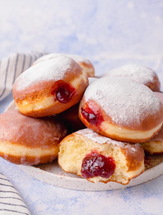 Polish doughnuts paczki on a white plate.