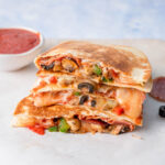 A stack of pizza quesadilla on a white board.