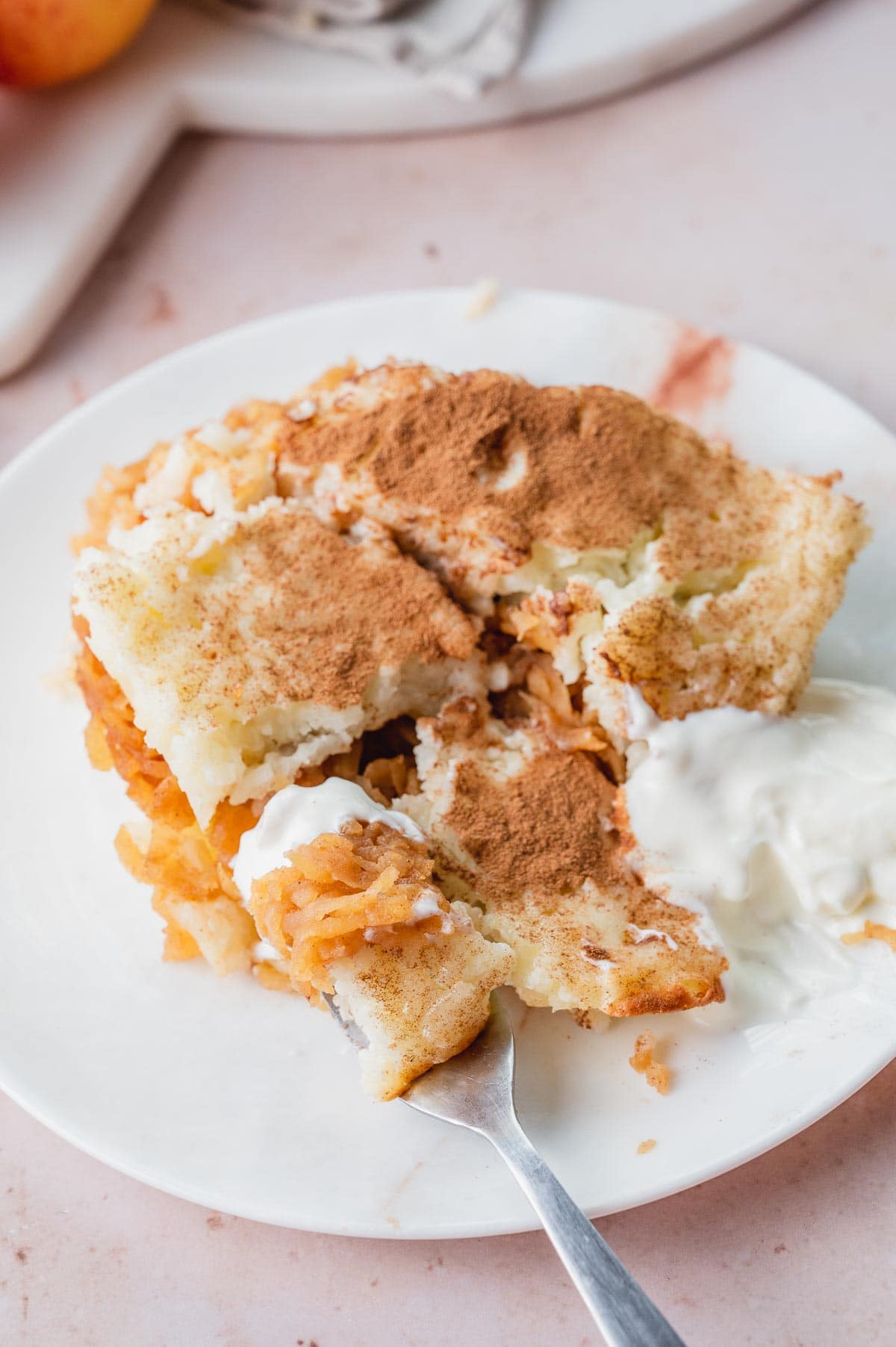 Polish rice and apples on a white plate with sweetened sour cream.