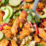 Sheet pan chicken Fajitas on a black baking sheet.