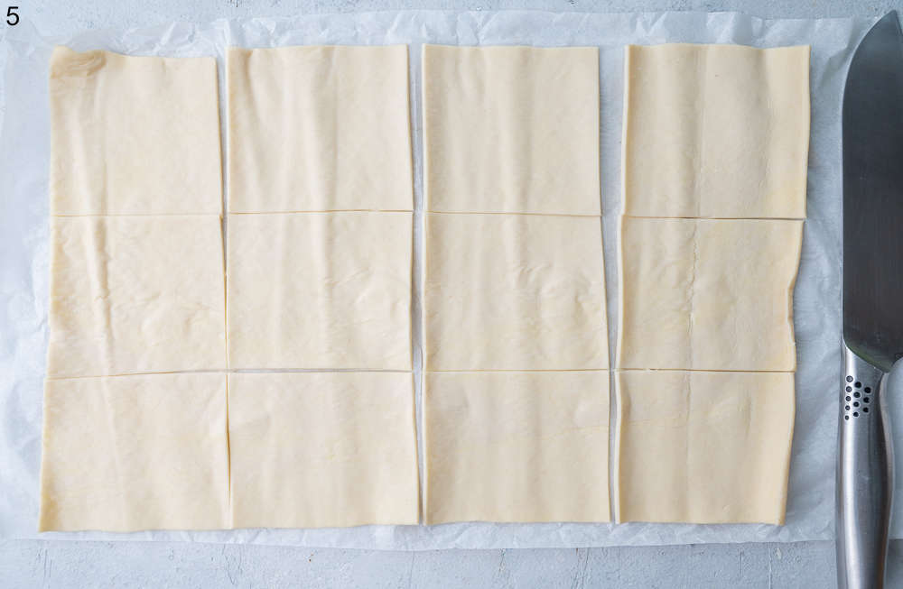 A sheet of puff pastry cut into 12 squares.