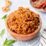 Sun-dried tomato pesto in a brown bowl.