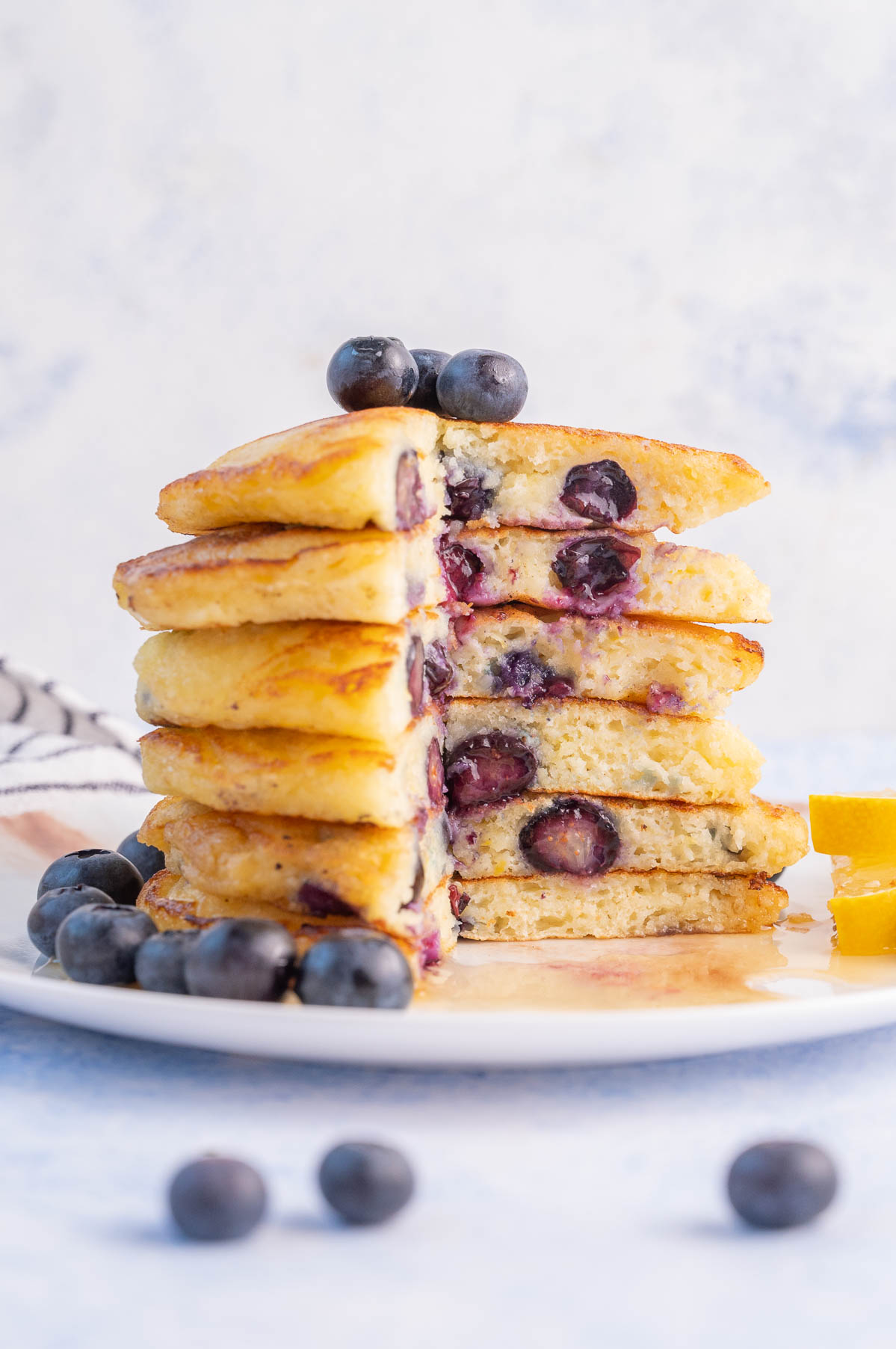 A stack of blueberry buttermilk pancakes with a part missing.