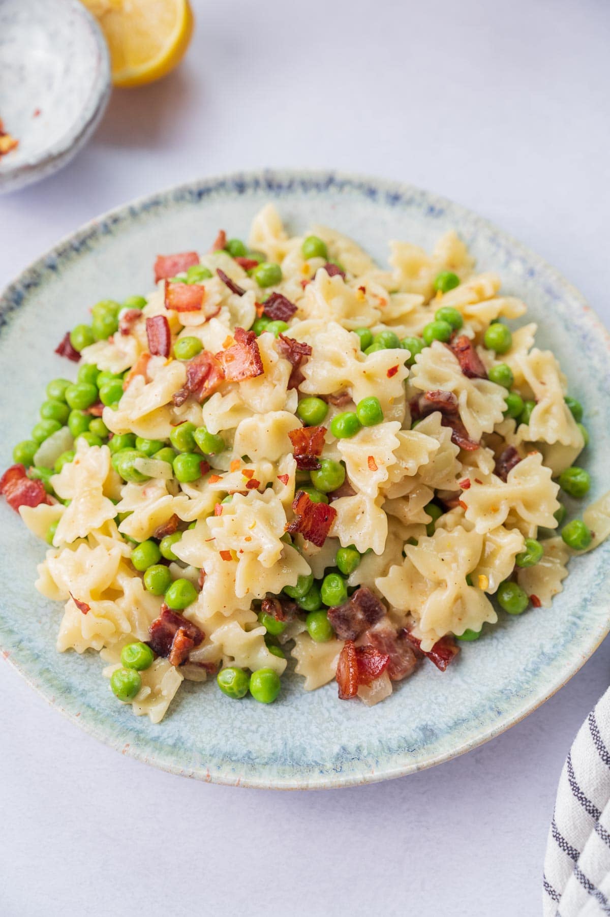 Bacon peas pasta on a blue plate,