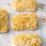 Parmesan crusted cod fillets on a baking sheet.
