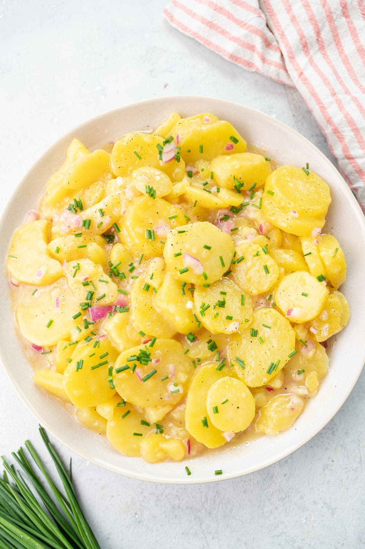 Austrian potato salad in a white bowl.