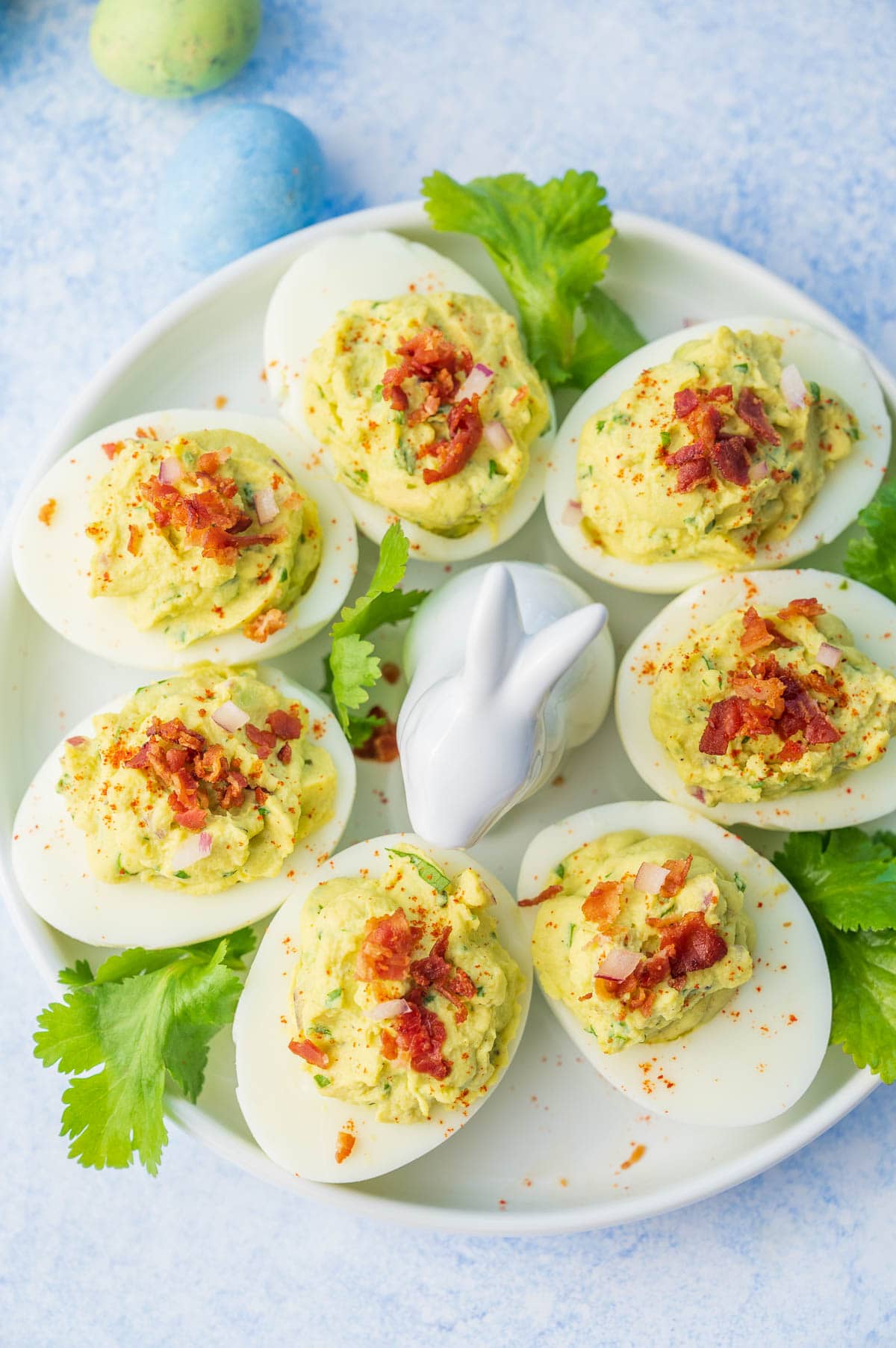 An overhead photo of avocado deviled eggs on a white plate.