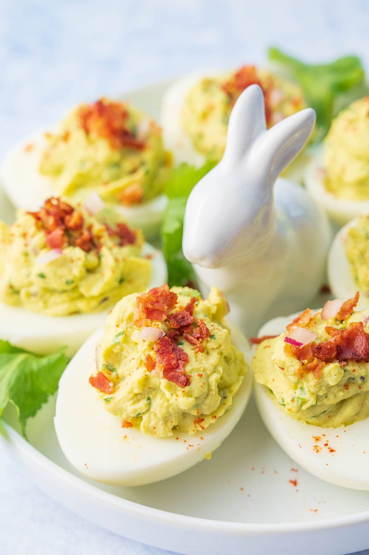 Avocado deviled eggs on a white plate.