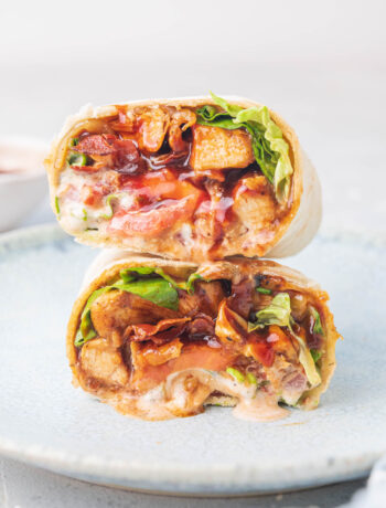 A stack of two bbq chicken wraps cut in half on a plate.