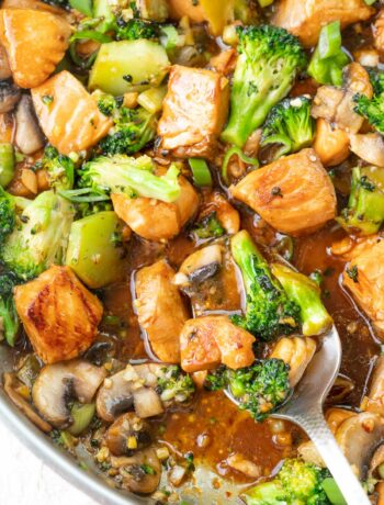 Salmon stir fry with broccoli and mushrooms in a frying pan.