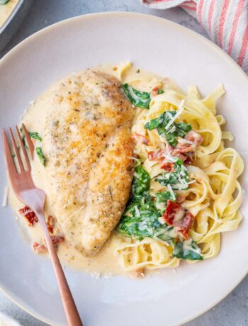 Tuscan chicken pasta on a beige plate.