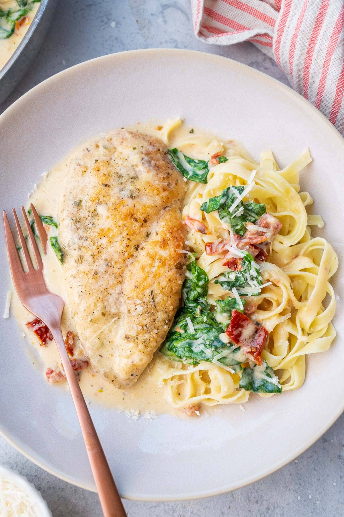 Tuscan chicken pasta on a beige plate.