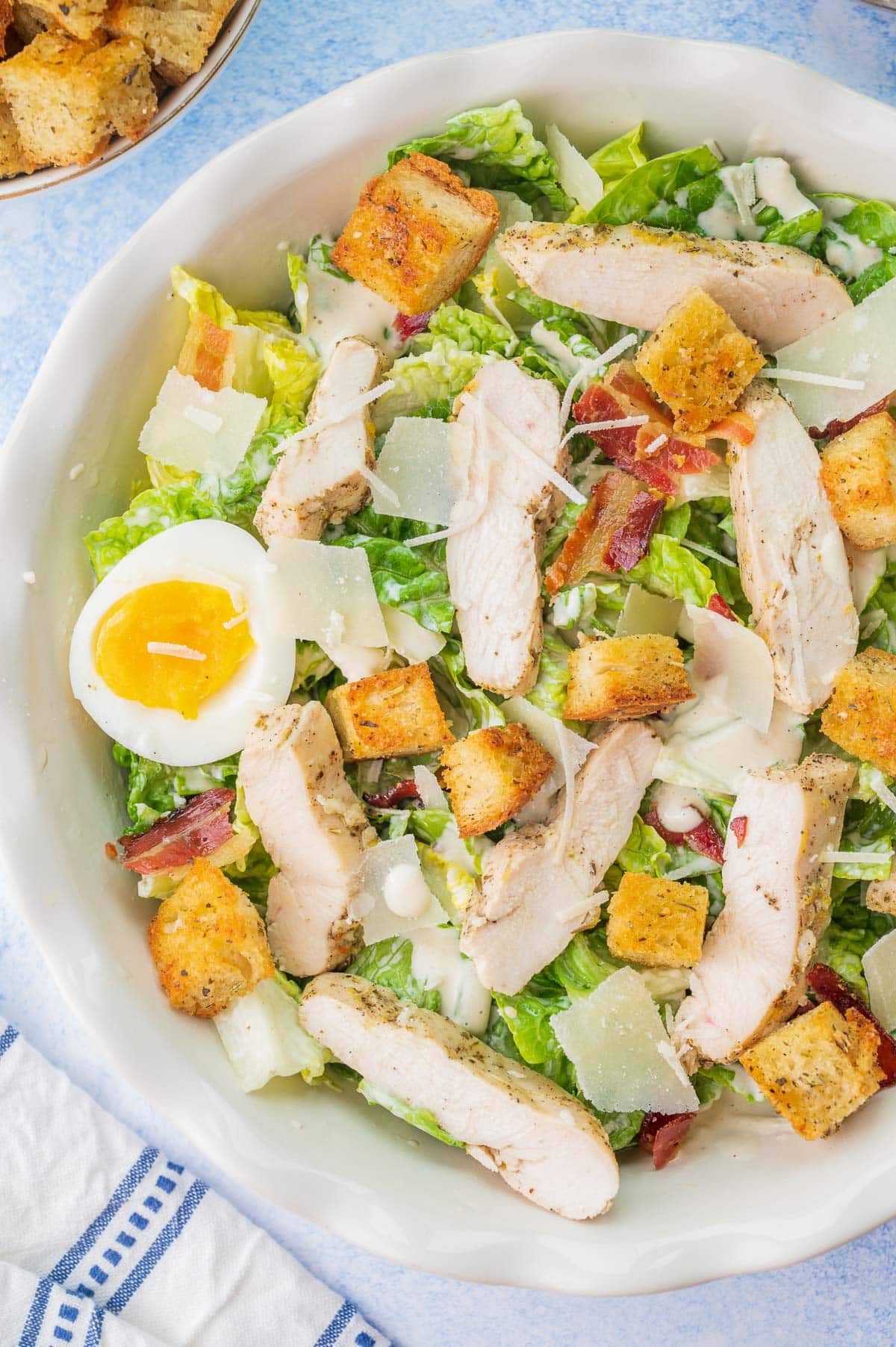 Chicken Caesar salad in a white bowl.