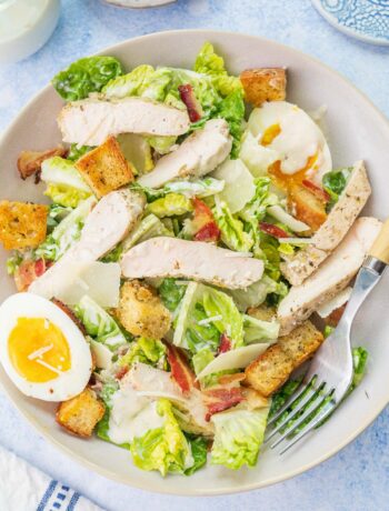 Chicken Caesar salad in a white bowl.