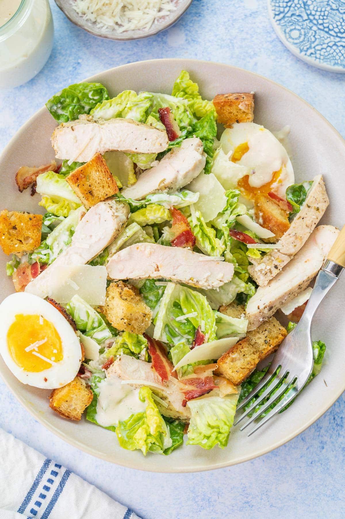 Chicken Caesar salad in a white bowl.