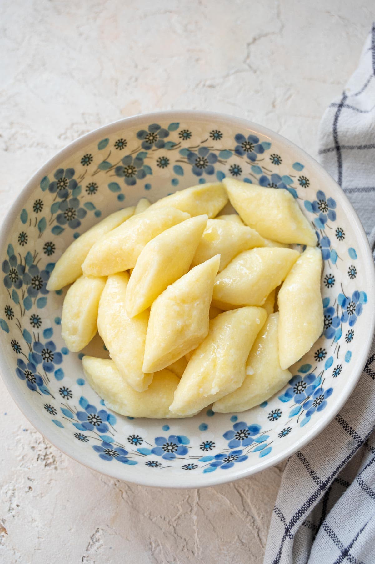 Leniwe dumplings in a white-blue bowl.