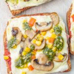 Pizza toast on a beige wooden board.