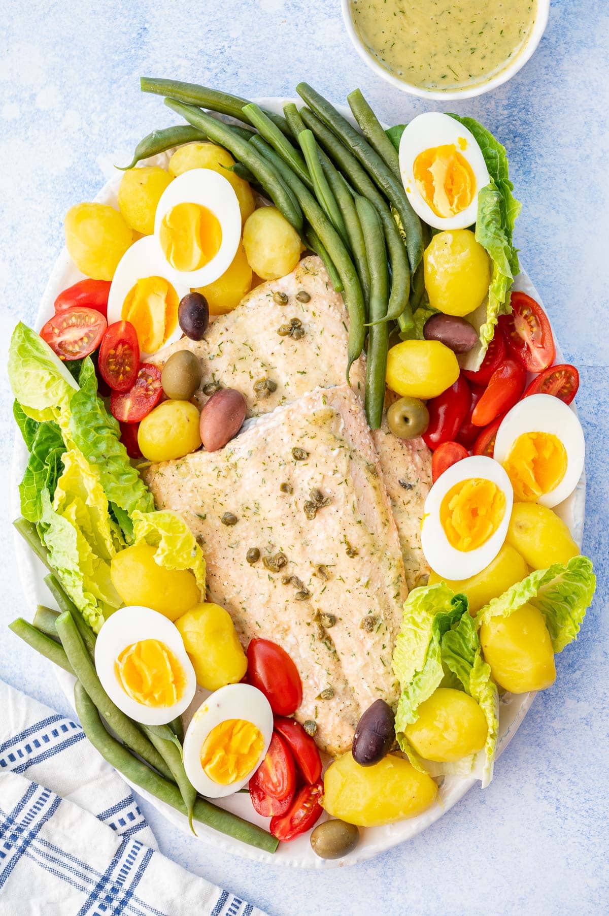 Salmon Nicoise salad on a white plate.