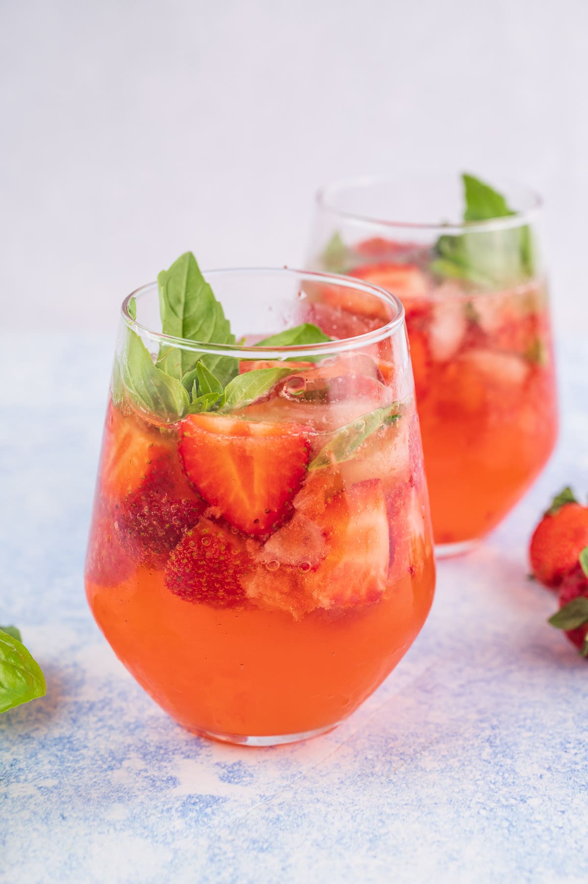 Two glasses with strawberry basil cocktail.