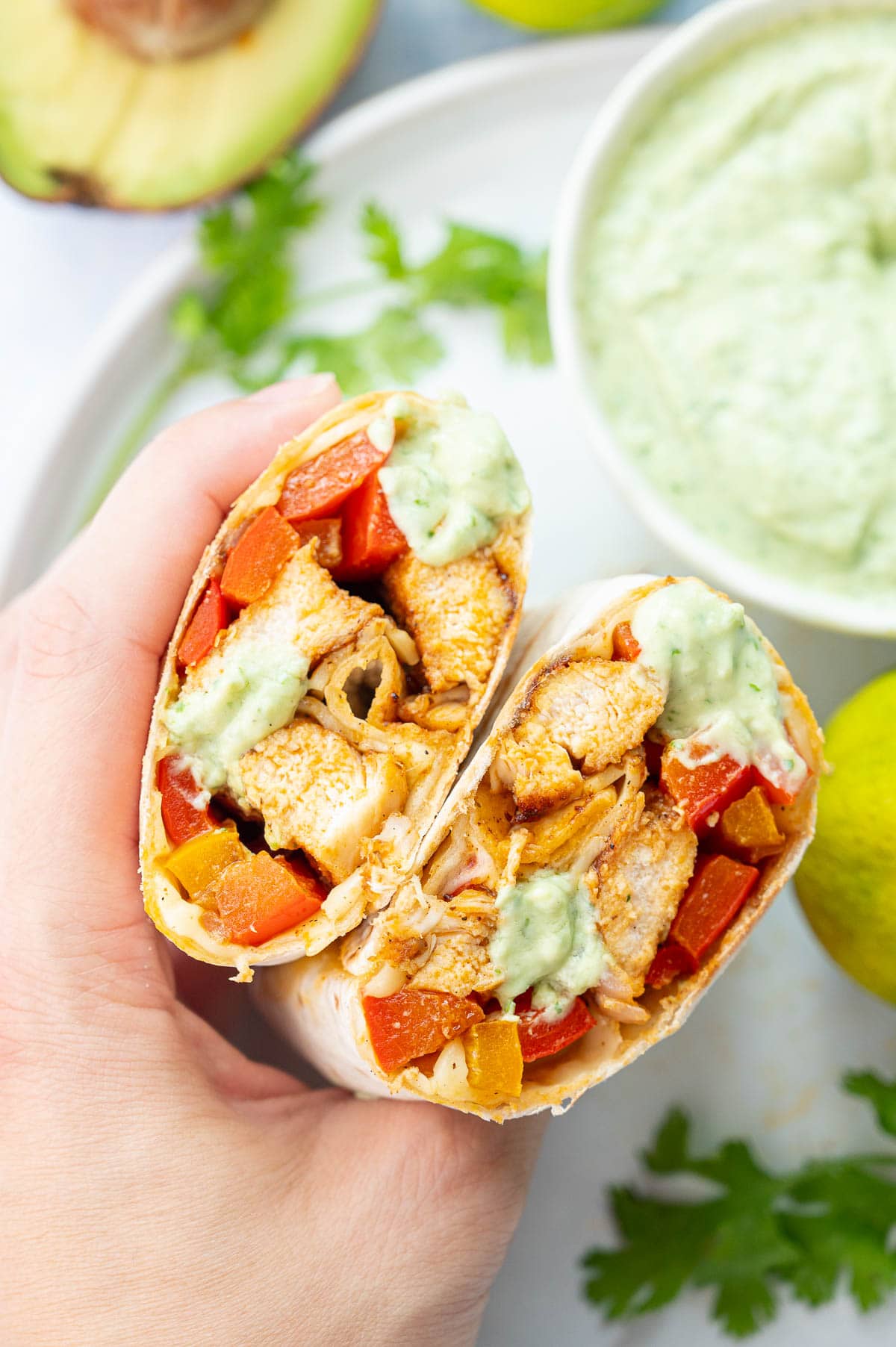 Two halves of chicken Fajita wraps helt in a hand.