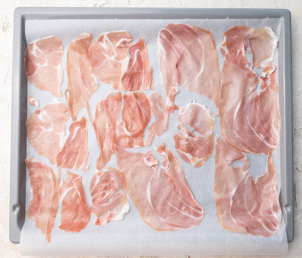 Prosciutto slices on a baking sheet.