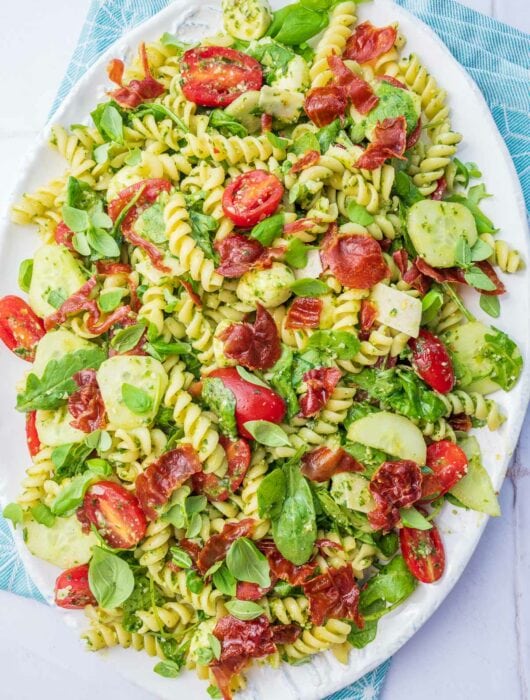 Pesto pasta salad on a white plate.