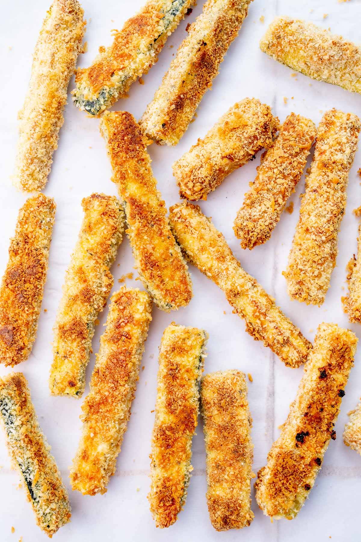 Zucchini fries on a piece of parchment paper.
