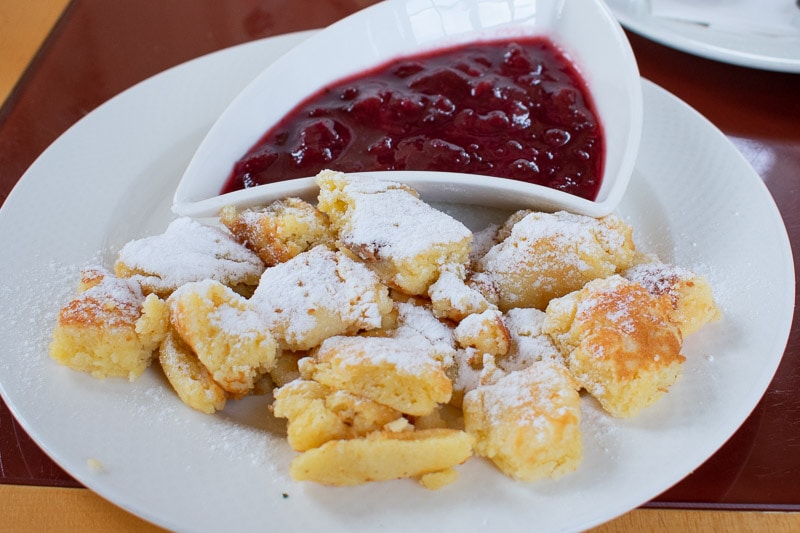 Kaiserschmarrn with plum compote on a white plate.