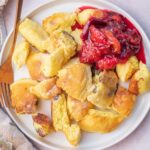 Kaiserschmarrn served with plum compote on a white plate.