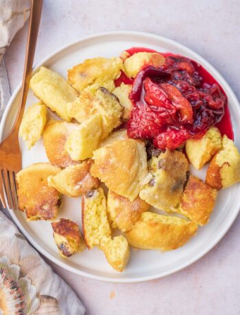 Kaiserschmarrn served with plum compote on a white plate.