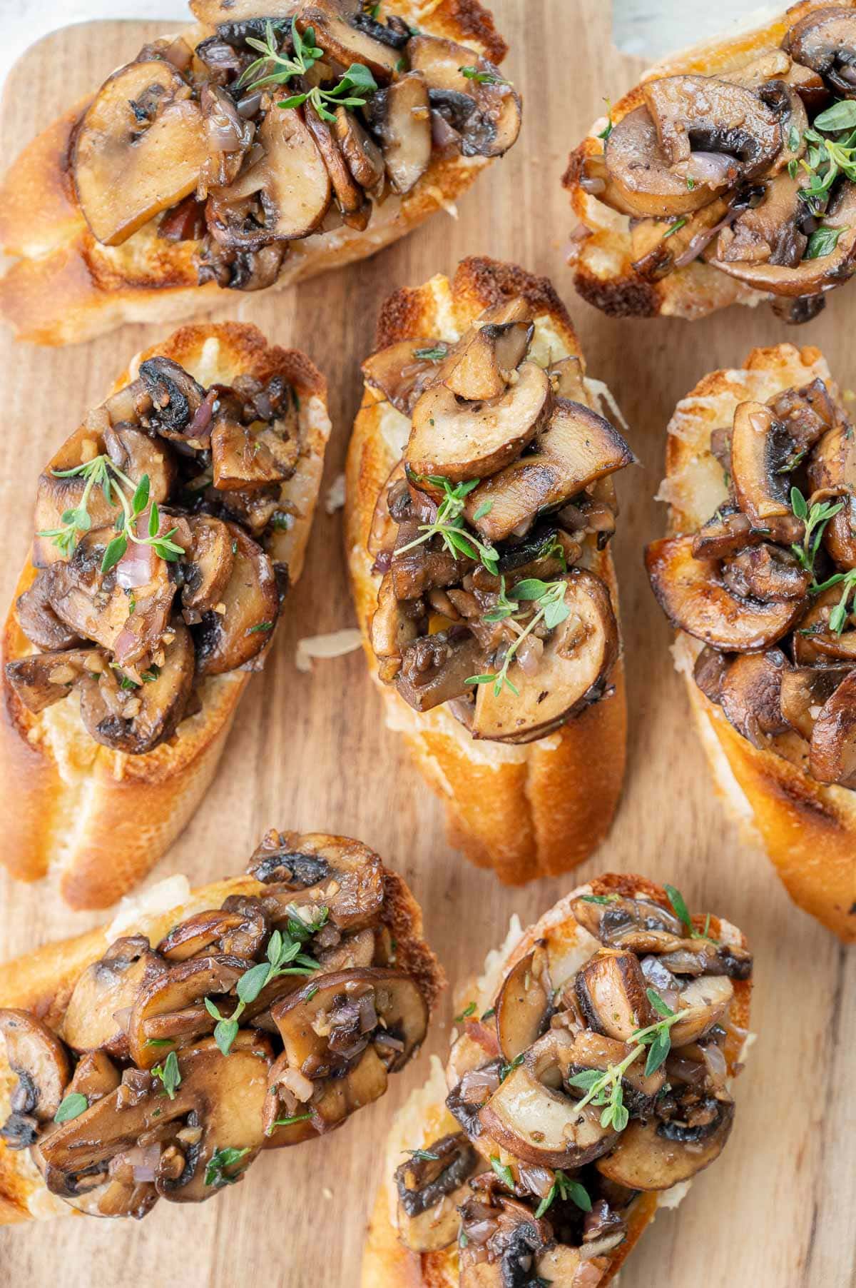 Mushroom bruschetta on a wooden board.