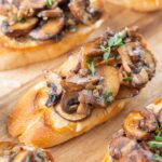 Mushroom bruschetta on a wooden board.