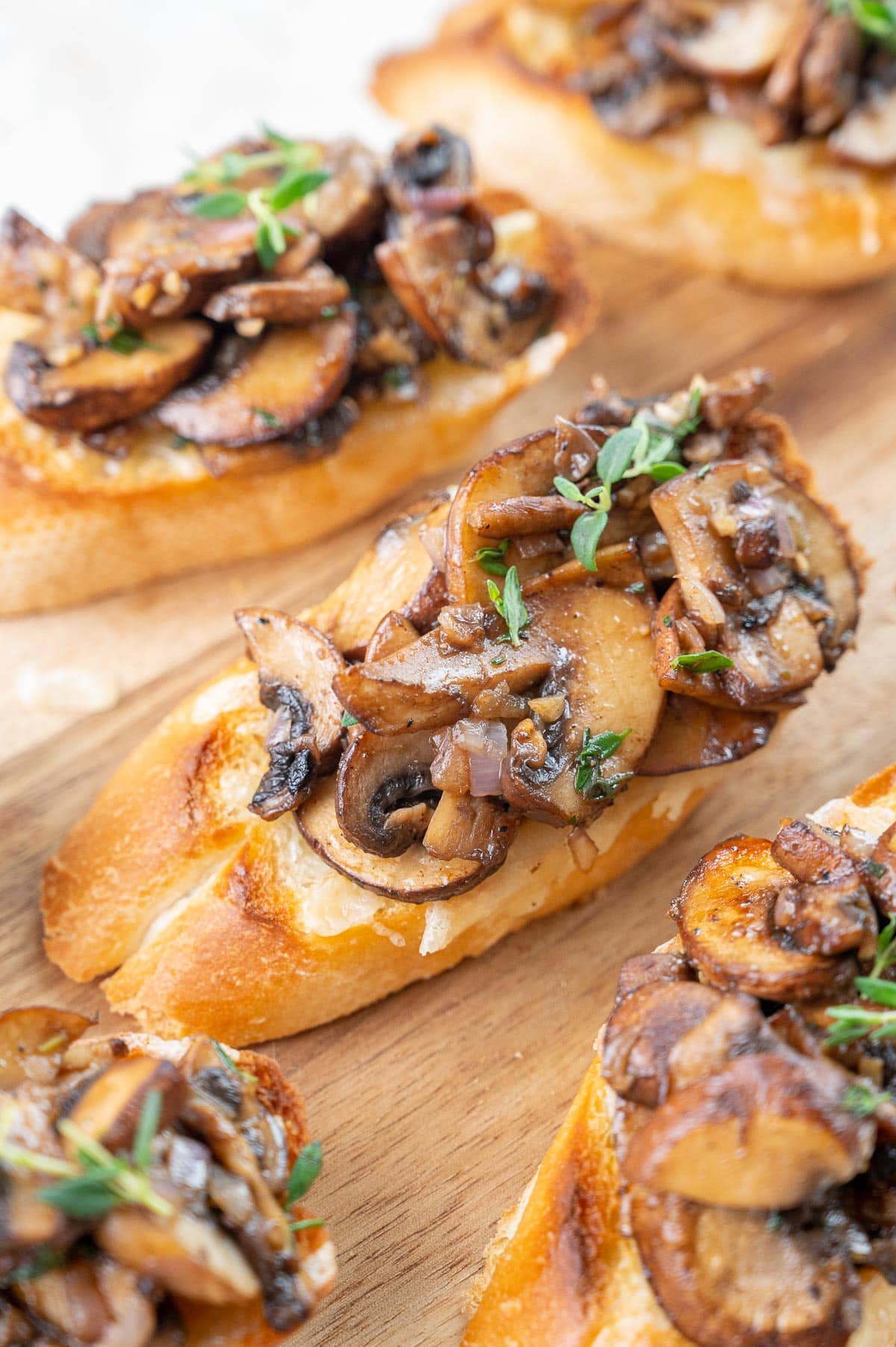 Mushroom bruschetta on a wooden board.