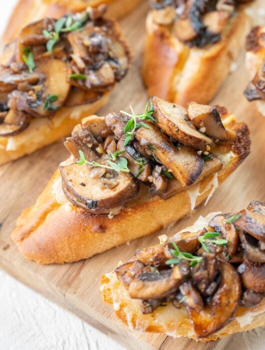 Mushroom bruschetta on a wooden board.