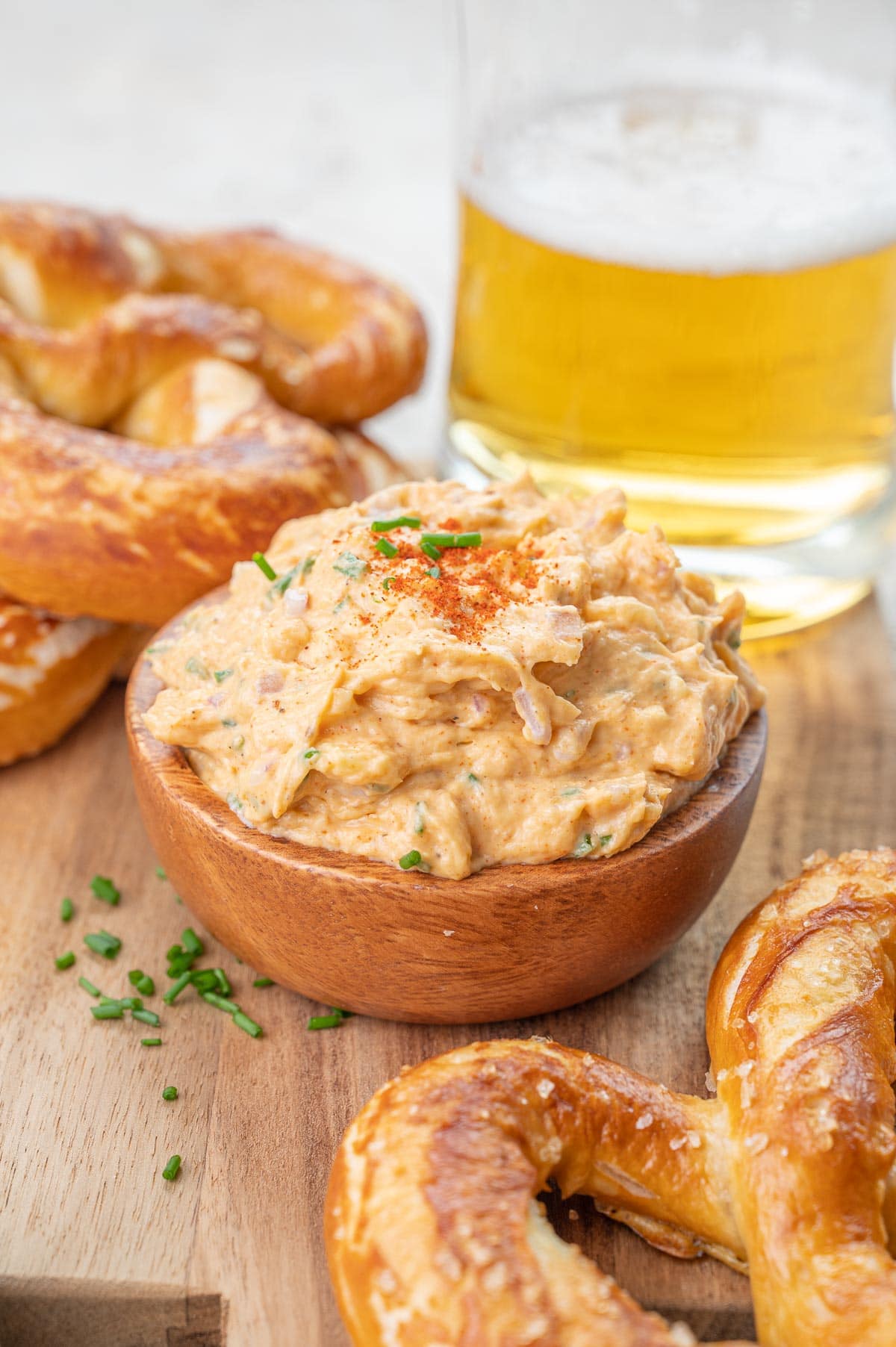 Obatzda dip in a brown bowl on a wooden board.