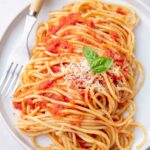 Spaghetti Pomodoro (from 'the Bear') on a white plate topped with parmesan.