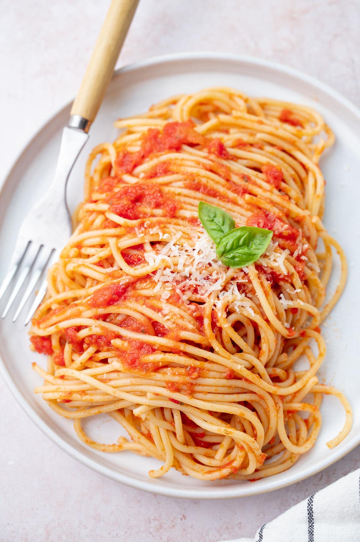 Spaghetti Pomodoro (from 'the Bear') on a white plate topped with parmesan.
