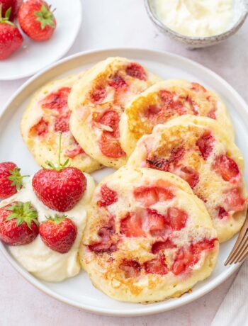 Strawberry pancakes on a white plate.