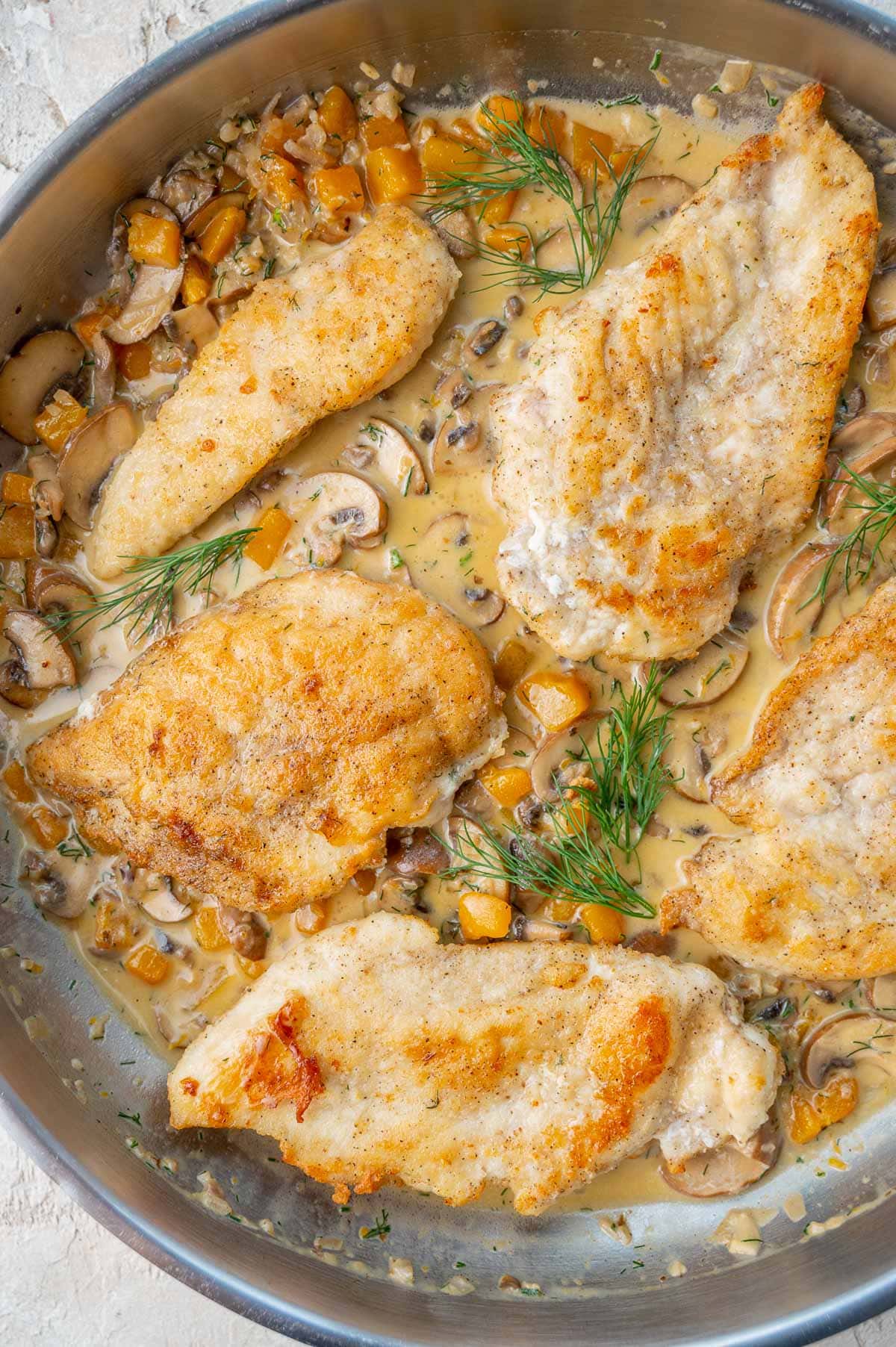 Chicken with Creamy Butternut Squash and Mushroom Sauce in a pan.