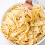 Garlic butter noodles in a white bowl.