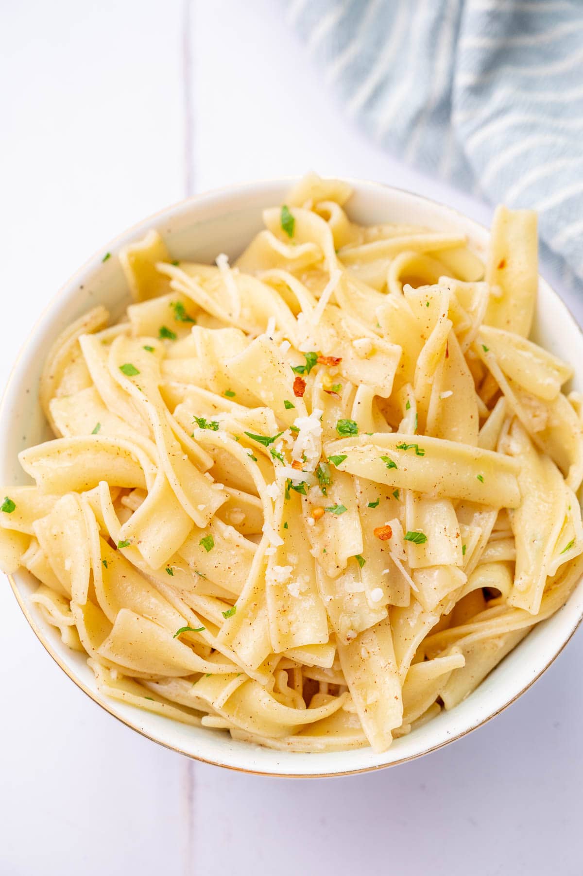 Buttered noodles in a white bowl.