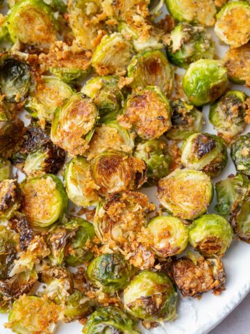 Parmesan roasted brussel sprouts on a white plate.