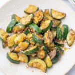 Sauteed zucchini on a beige plate.