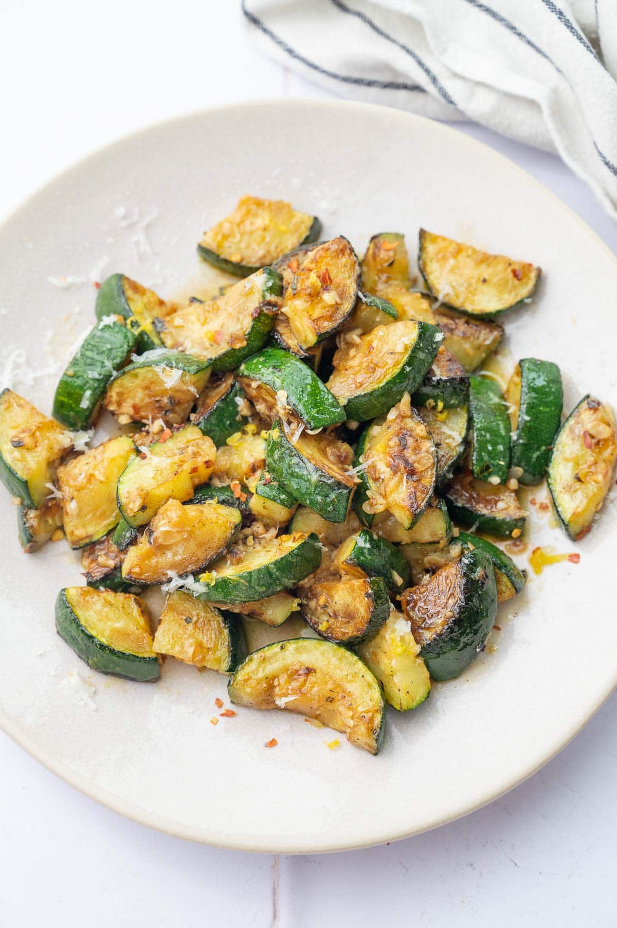 Sauteed zucchini on a beige plate.