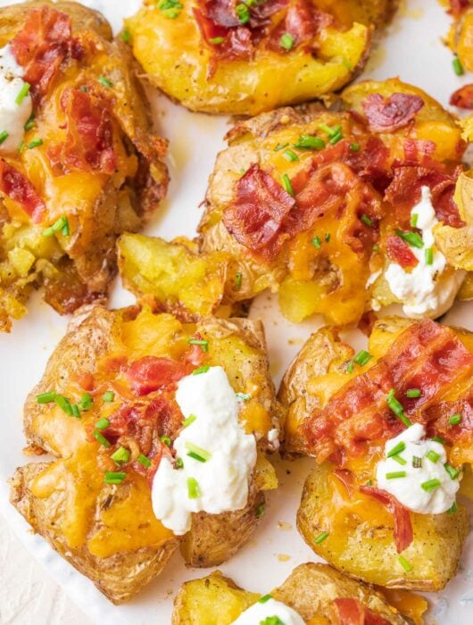 Loaded Smashed Potatoes on a white plate.