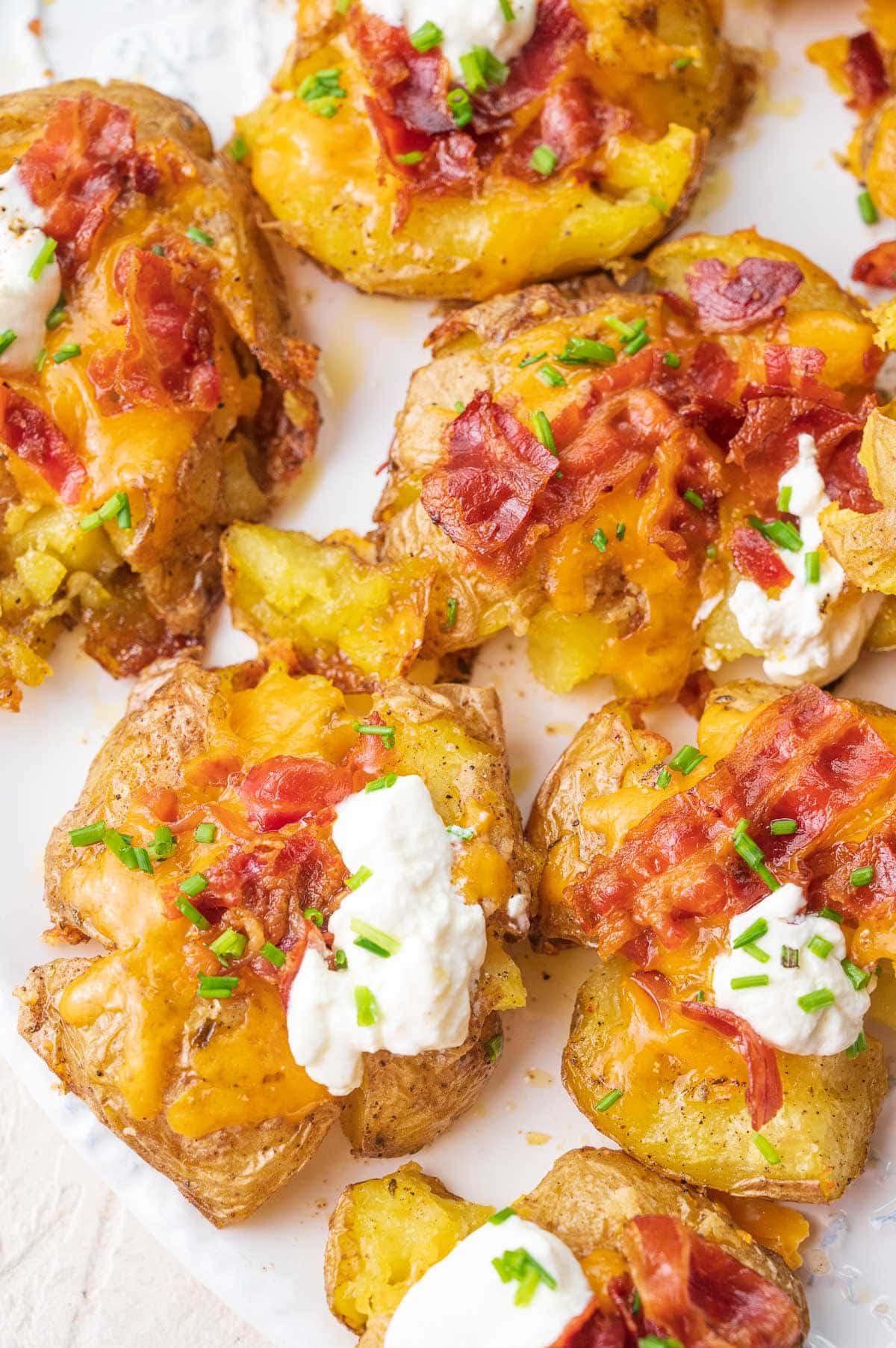 Loaded Smashed Potatoes on a white plate.